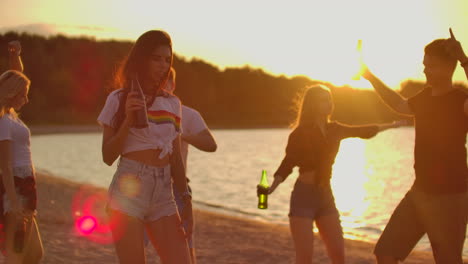 The-girl-with-dark-hair-is-dancing-with-nude-waist-on-the-open-air-party-with-beer.-It-is-crazy-and-hot-beach-party-with-the-best-friends-in-the-good-mood.